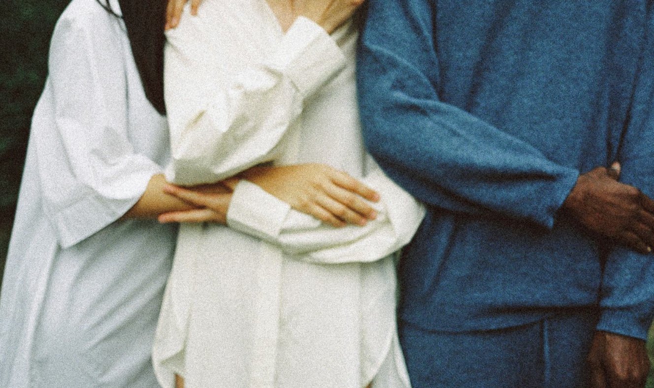 Three people standing arm in arm