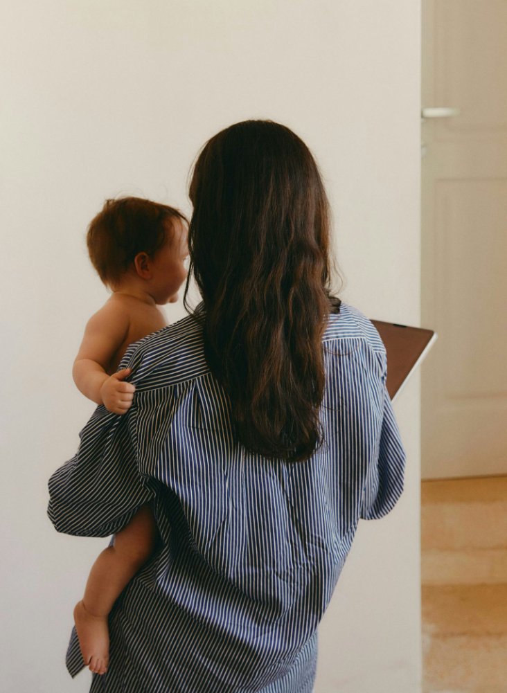 A parent at home, carrying their child down the hall
