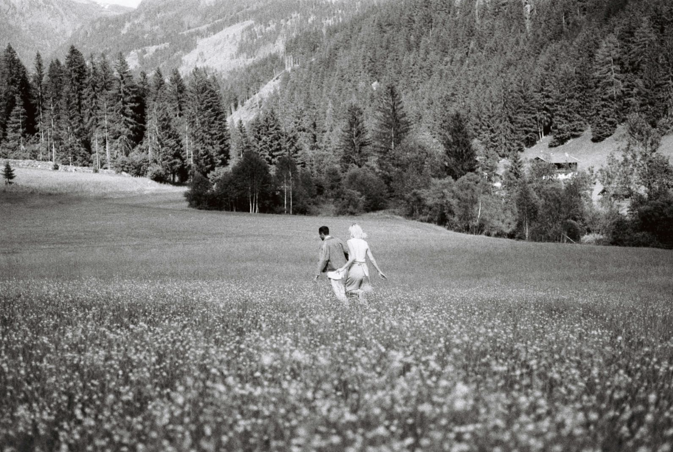 A couple walking together through an alpine wildflower meadow